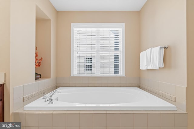 bathroom with tiled tub and vanity