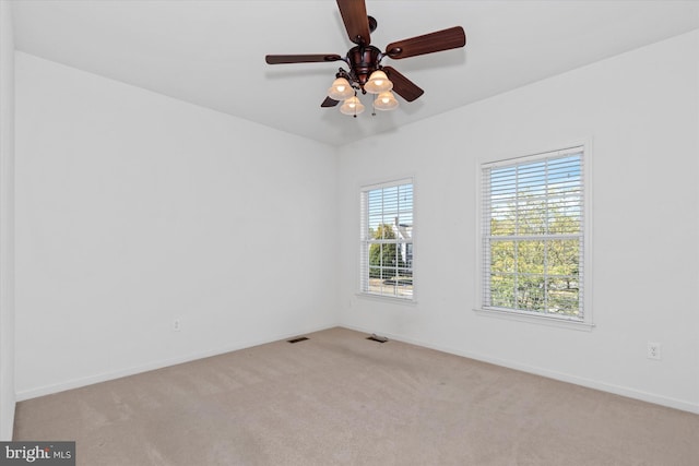 carpeted spare room with ceiling fan