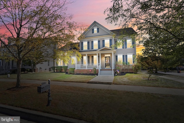 view of front of property with a lawn and covered porch