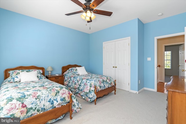 bedroom featuring light carpet, ceiling fan, and a closet