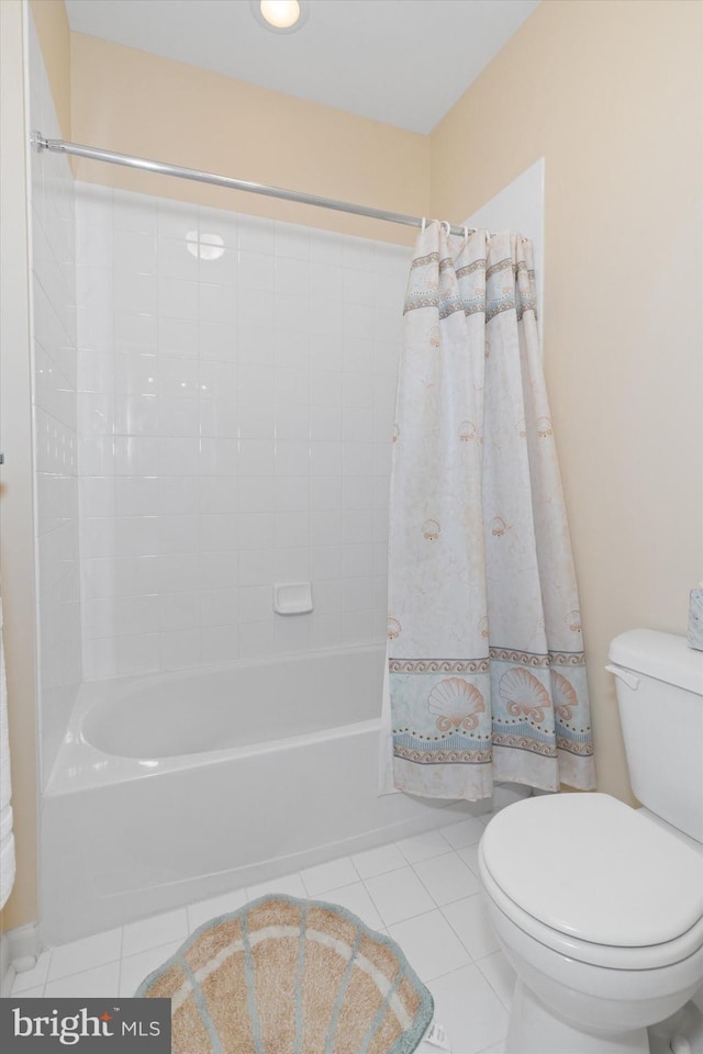 bathroom featuring shower / bath combination with curtain, tile patterned floors, and toilet