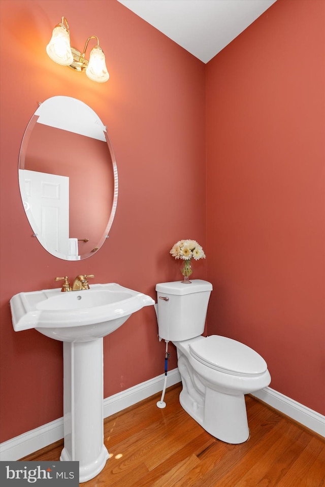 bathroom with hardwood / wood-style floors, sink, and toilet