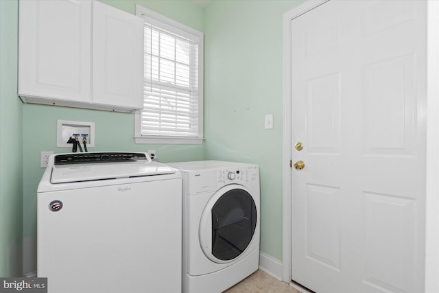 clothes washing area featuring washer and dryer and cabinets