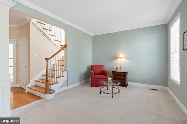 living area with crown molding and light colored carpet