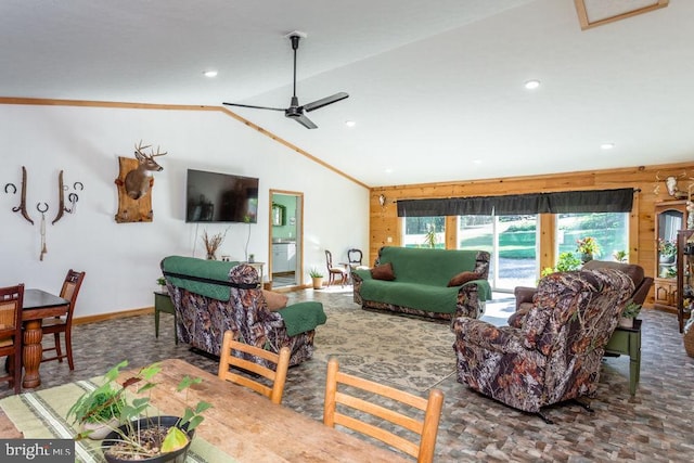 living room with lofted ceiling, ornamental molding, wooden walls, and ceiling fan