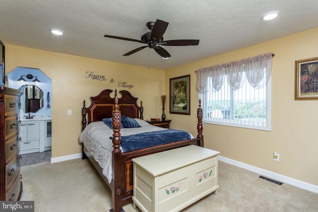 carpeted bedroom featuring ceiling fan, sink, and a textured ceiling