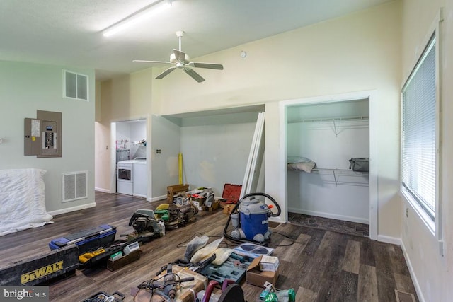 bedroom featuring ceiling fan, electric panel, a closet, dark hardwood / wood-style floors, and washer and dryer