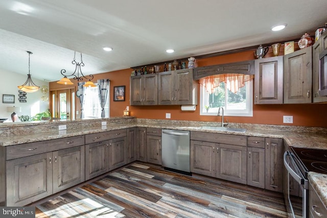 kitchen with hanging light fixtures, dark wood-type flooring, sink, and stainless steel appliances