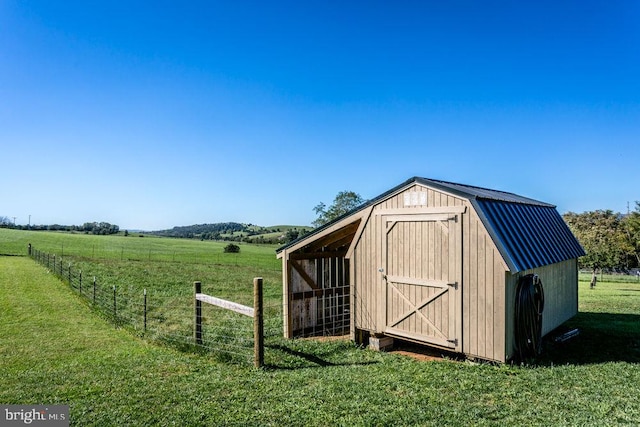 view of outbuilding with a rural view and a lawn