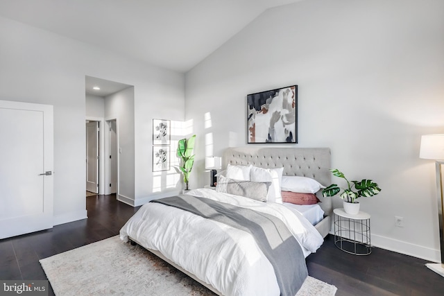 bedroom with dark wood-type flooring and lofted ceiling