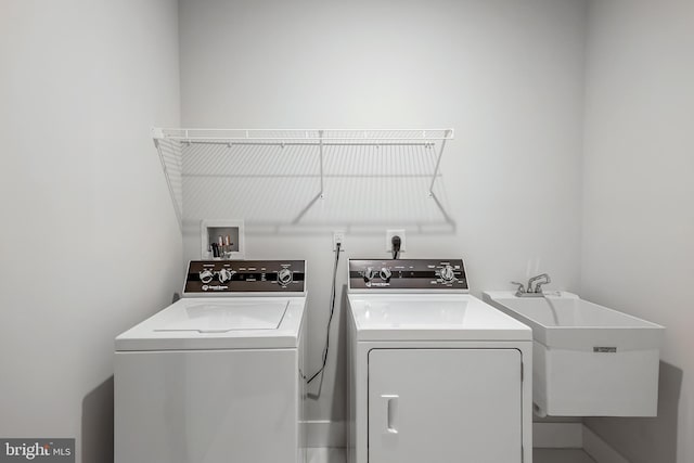 clothes washing area featuring separate washer and dryer and sink