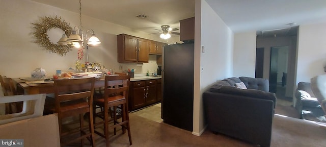 kitchen featuring carpet, decorative light fixtures, ceiling fan with notable chandelier, and stainless steel refrigerator