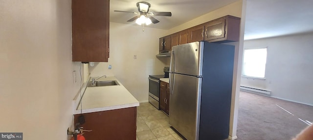 kitchen featuring a baseboard heating unit, range hood, a sink, stainless steel appliances, and a ceiling fan