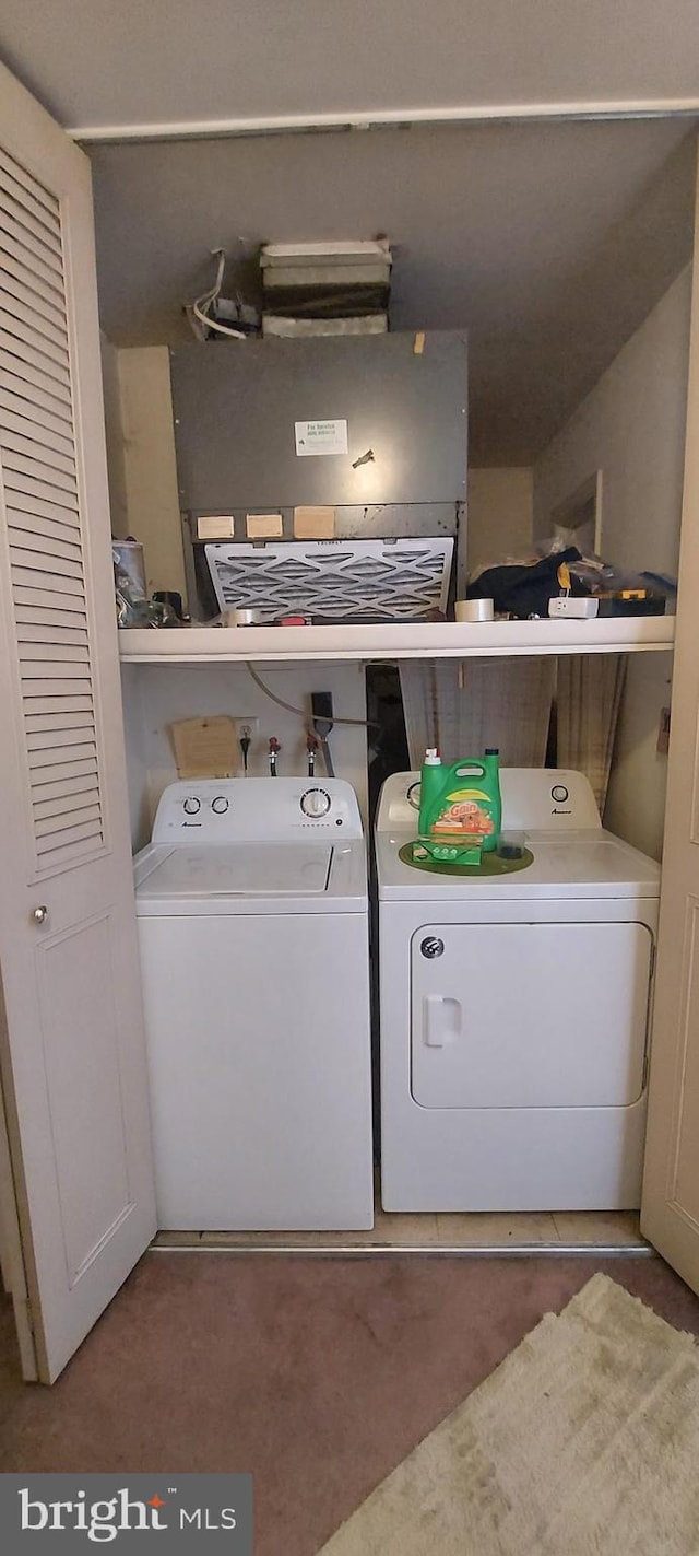 washroom with washing machine and clothes dryer and carpet flooring