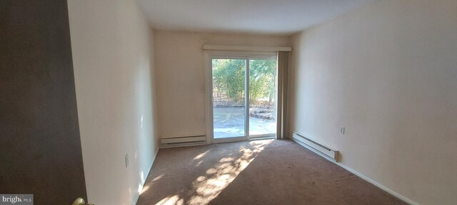 empty room featuring baseboard heating and carpet flooring