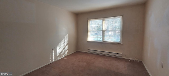 spare room featuring baseboard heating, carpet, and baseboards