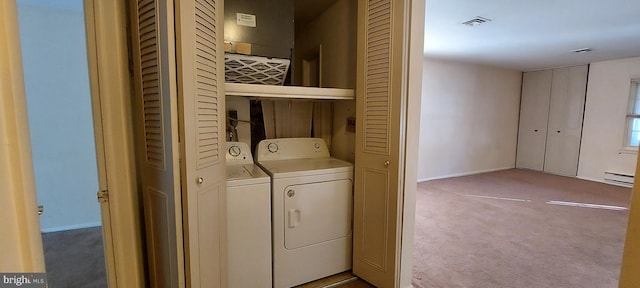 washroom featuring a baseboard radiator, carpet, washer and clothes dryer, and laundry area
