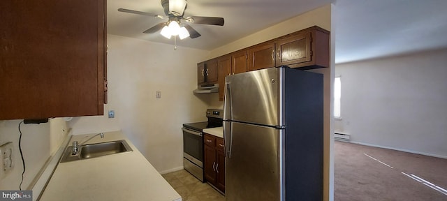 kitchen with a baseboard heating unit, range hood, a sink, ceiling fan, and appliances with stainless steel finishes