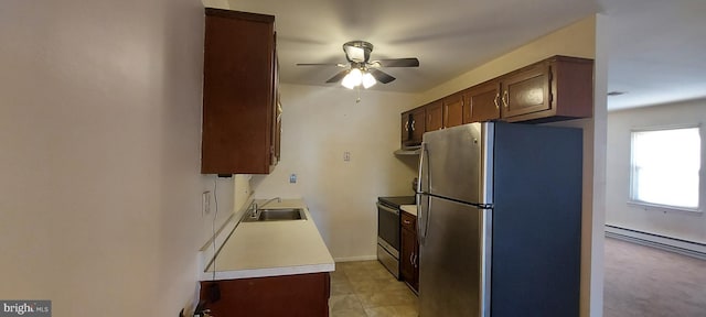 kitchen with a sink, a ceiling fan, light countertops, baseboard heating, and appliances with stainless steel finishes