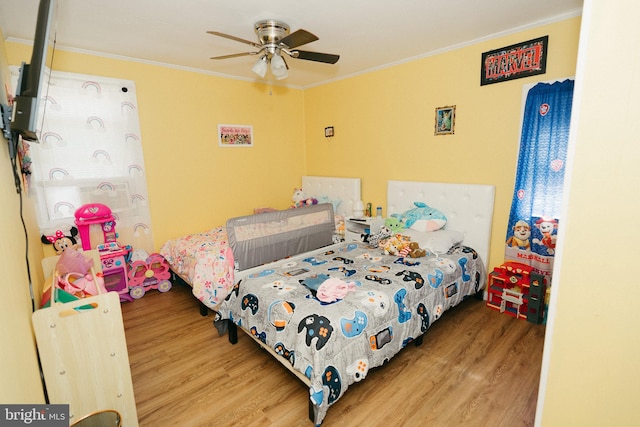 bedroom featuring crown molding, hardwood / wood-style floors, and ceiling fan