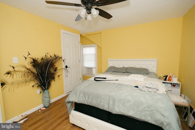 bedroom featuring wood-type flooring, cooling unit, and ceiling fan