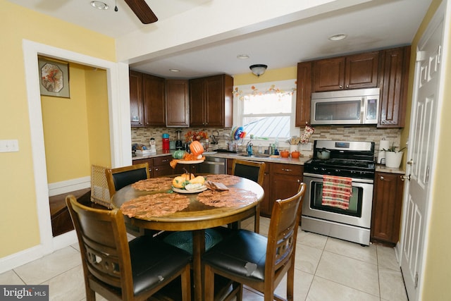 kitchen with ceiling fan, light tile patterned floors, dark brown cabinets, backsplash, and appliances with stainless steel finishes