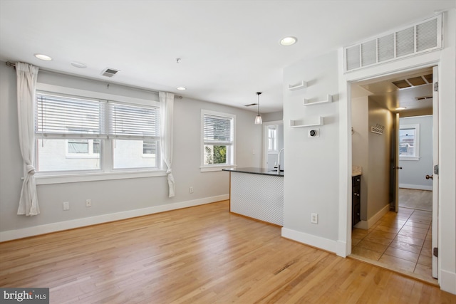 interior space with pendant lighting and light wood-type flooring