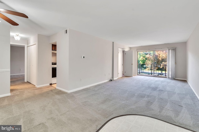 unfurnished living room featuring light carpet and ceiling fan