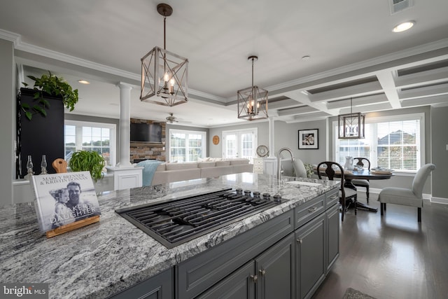 kitchen featuring ornate columns, light stone countertops, dark hardwood / wood-style floors, and stainless steel gas stovetop