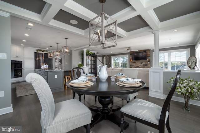 dining area with ceiling fan with notable chandelier, ornate columns, dark hardwood / wood-style floors, and a healthy amount of sunlight