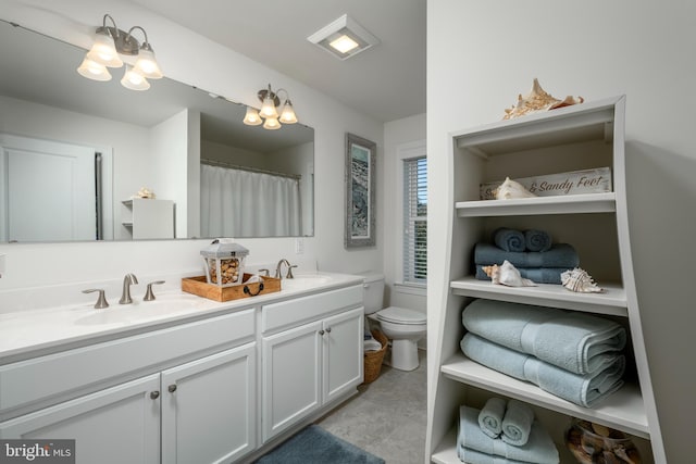 bathroom with toilet, an inviting chandelier, and vanity