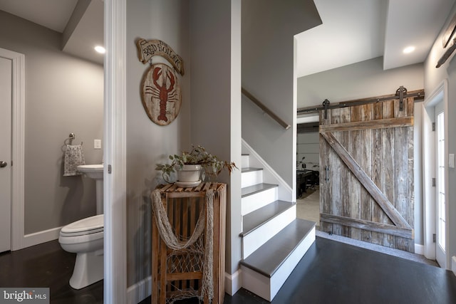 stairs featuring wood-type flooring and a barn door