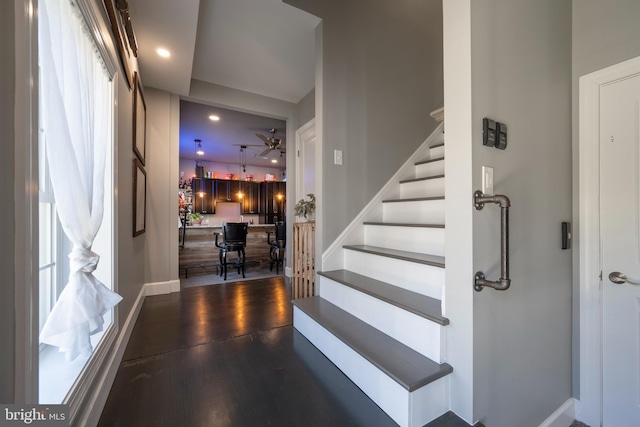 stairway with hardwood / wood-style flooring and ceiling fan