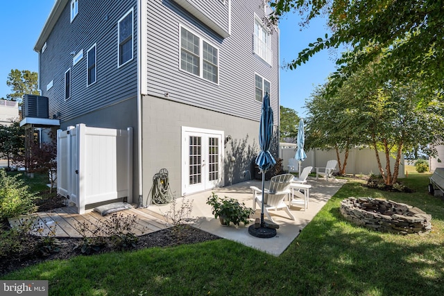 rear view of property with an outdoor fire pit, french doors, a yard, and a patio