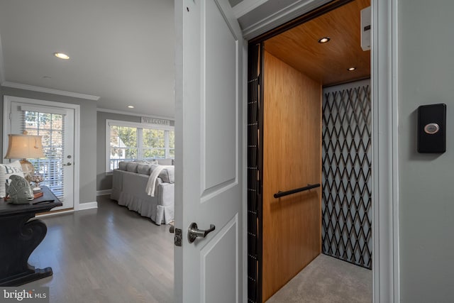 interior space with light hardwood / wood-style flooring, ornamental molding, wood ceiling, and elevator