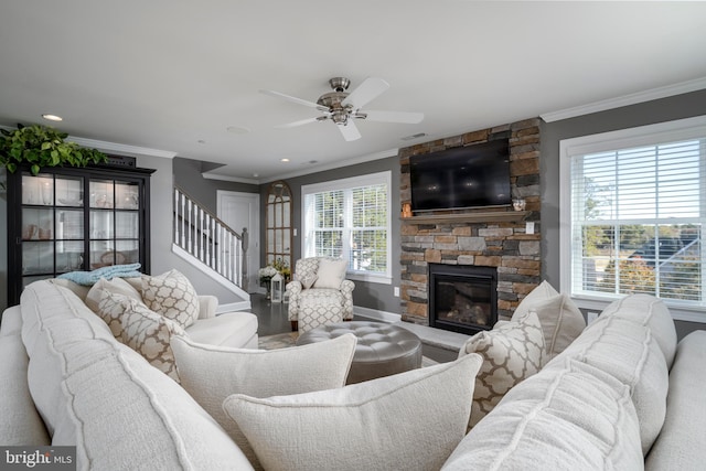 living room with crown molding, a healthy amount of sunlight, and a fireplace