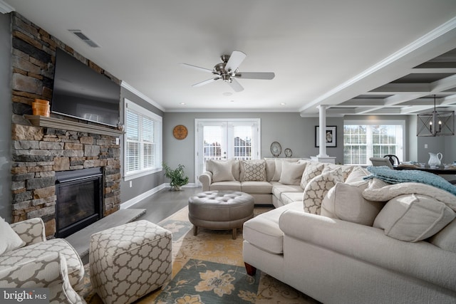 living room with a wealth of natural light, ornamental molding, decorative columns, and a fireplace