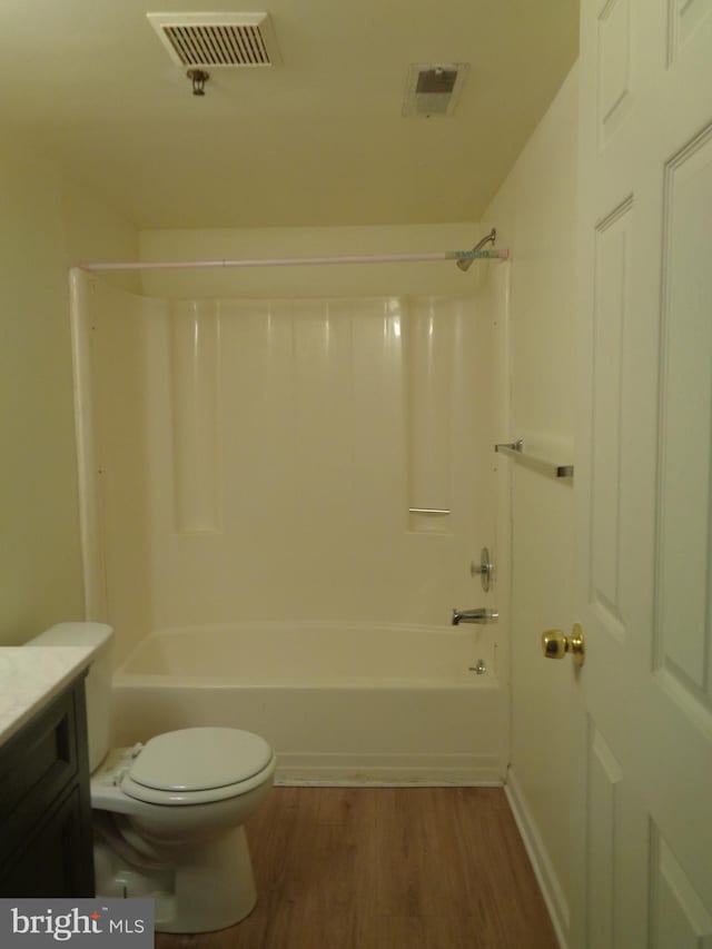 full bathroom with wood-type flooring,  shower combination, vanity, and toilet