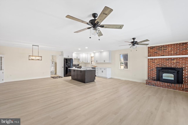 unfurnished living room featuring ceiling fan and light hardwood / wood-style flooring