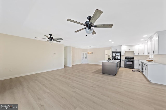 kitchen with black appliances, a center island, white cabinetry, light hardwood / wood-style floors, and pendant lighting