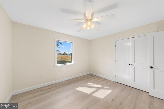 unfurnished bedroom featuring light hardwood / wood-style flooring, a closet, and ceiling fan