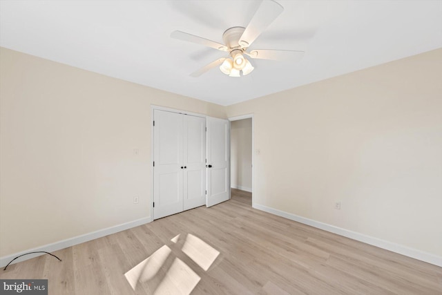 unfurnished bedroom featuring light hardwood / wood-style flooring, a closet, and ceiling fan