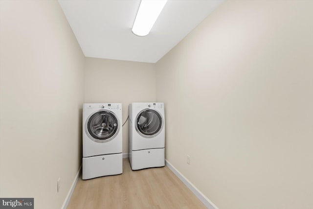 washroom with washer and dryer and light hardwood / wood-style flooring