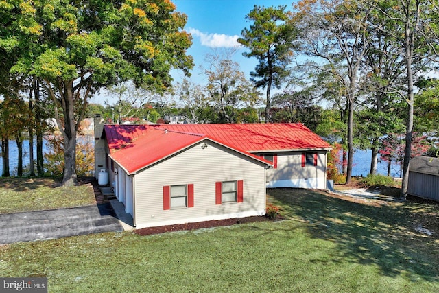 view of property exterior with a water view and a yard