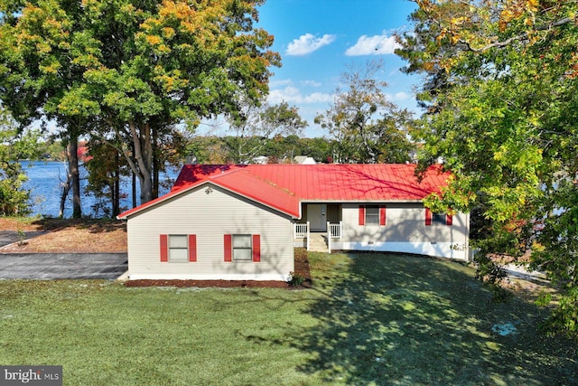 ranch-style house with a front lawn and a water view