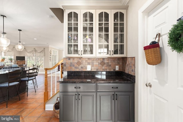 kitchen featuring gray cabinetry, hanging light fixtures, backsplash, crown molding, and light tile patterned flooring