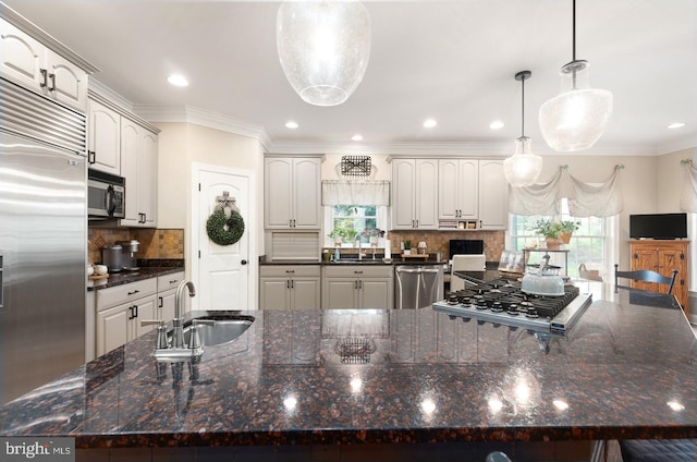 kitchen featuring appliances with stainless steel finishes, decorative light fixtures, white cabinetry, and a large island