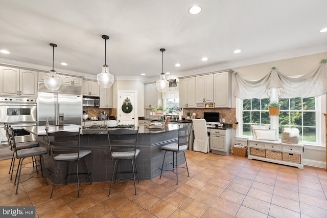 kitchen featuring decorative backsplash, decorative light fixtures, stainless steel appliances, and a center island with sink