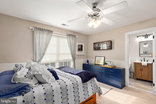 carpeted bedroom featuring ceiling fan and ensuite bathroom