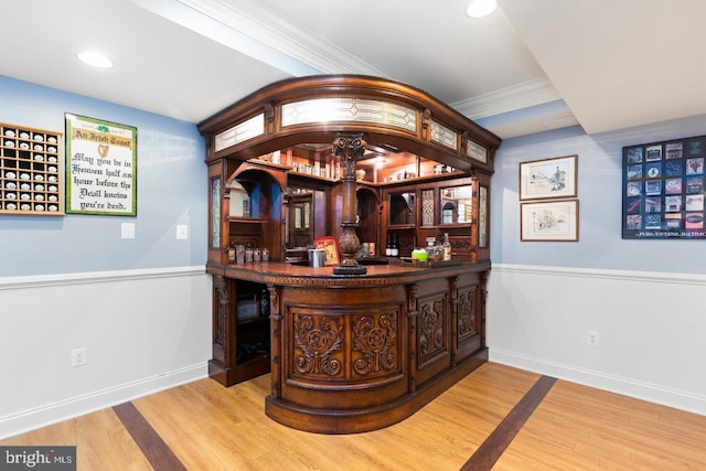 bar featuring crown molding and hardwood / wood-style floors